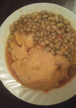 A picture of Mashed potatoes with stewed beans.