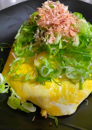 A picture of Omu-Okonomiyaki (Japanese as-you-like pancake wrapped with egg).