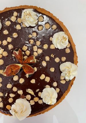 Zdjęcie przepisu Tarta z ganache czekoladowym i orzechami laskowymi.