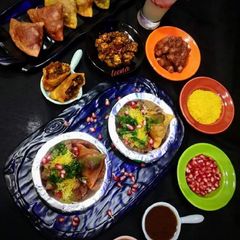 A picture of Achari paneer tikka samosa chaat with peshwari chole.