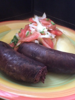 Una foto de Prietas con papas cocidas y ensalada a la chilena