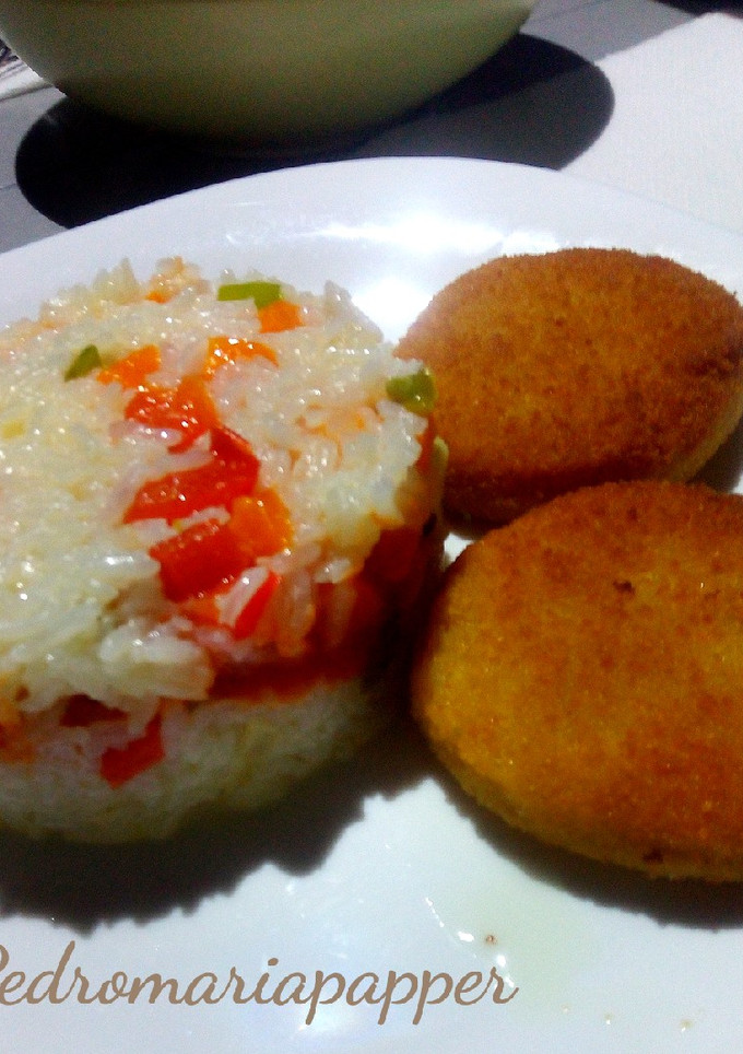 Una foto de Rodajas de merluza con arroz, tomate y huevo