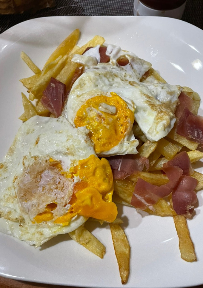 Una foto de Huevos rotos con jamón