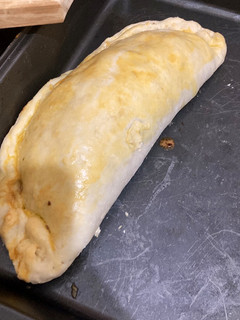 Una foto de Calzone relleno de carne y verduras