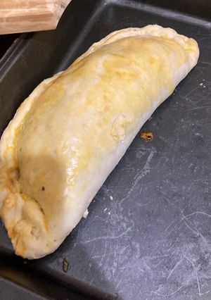 Una foto de Calzone relleno de carne y verduras