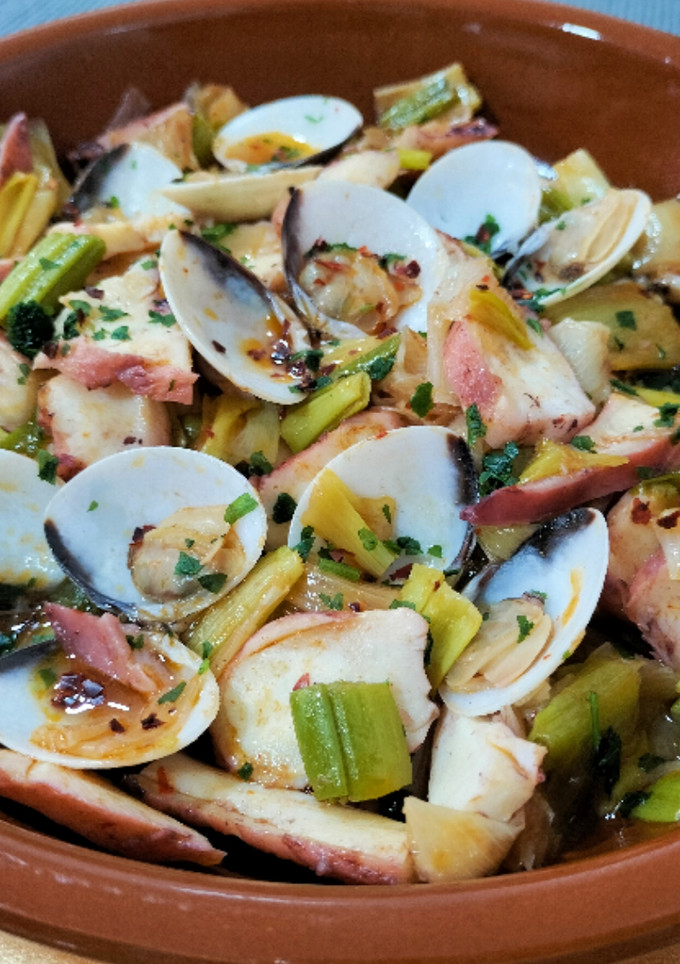 Una foto de Wok de calçots, pota y almejas