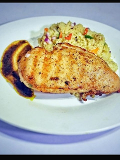A picture of Grilled chicken with Gravy Jus and buttered couscous.