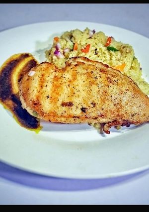 A picture of Grilled chicken with Gravy Jus and buttered couscous.