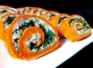 Foto principal de Rollo de pimientos de piquillo relleno de rúcula, queso de cabra y nueces