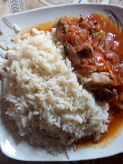 A picture of White rice and chicken sauce with curry leaf.
