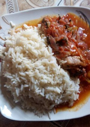 A picture of White rice and chicken sauce with curry leaf.