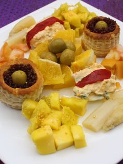 Una foto de Volovanes y huevos rellenos acompañados de naranja, mango y espárragos