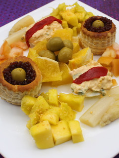 Una foto de Volovanes y huevos rellenos acompañados de naranja, mango y espárragos