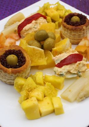 Una foto de Volovanes y huevos rellenos acompañados de naranja, mango y espárragos