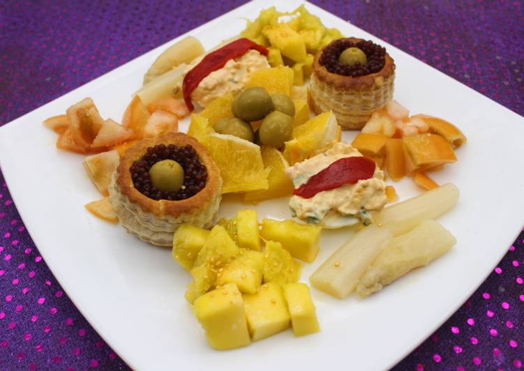 Volovanes y huevos rellenos acompañados de naranja, mango y espárragos