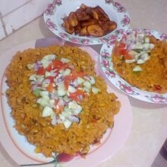 A picture of Jollop rice and beans with fried plantain.