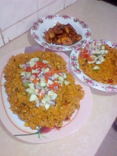 A picture of Jollop rice and beans with fried plantain.