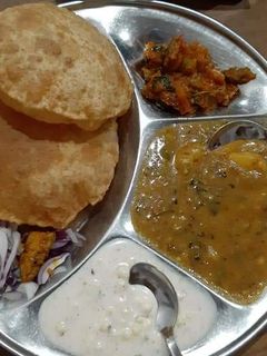 A picture of Aloo ki sbzi with puri.