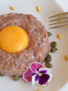 Una foto de Steak tartar de ternera coronado con huevo