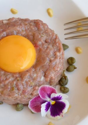Una foto de Steak tartar de ternera coronado con huevo