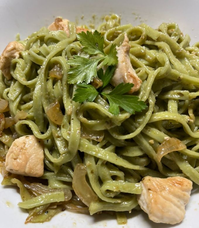 Una foto de Pasta con salsa de pollo, pesto y cebolla