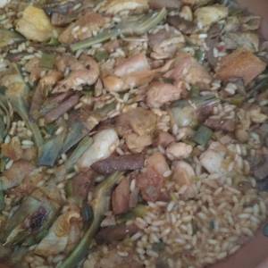 Sartén de arroz con pollo, setas y alcachofas