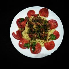A picture of Stewed beef with green peas and spaghetti.