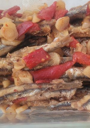 Una foto de Boquerones fritos con requemao de ajos, pimientos morrones, cayena y vinagre