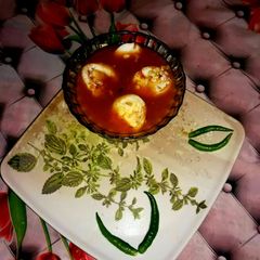 A picture of Veg clear soup with sliced boiled egg.