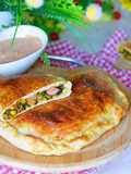 Calzone z kiełbasą w towarzystwie szpinaku i kolorowych warzyw