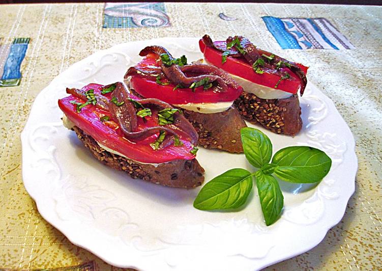 Anchoas, tomates cornudo de Andes y mozzarella sobre rebana de baguette de semillas - tapas