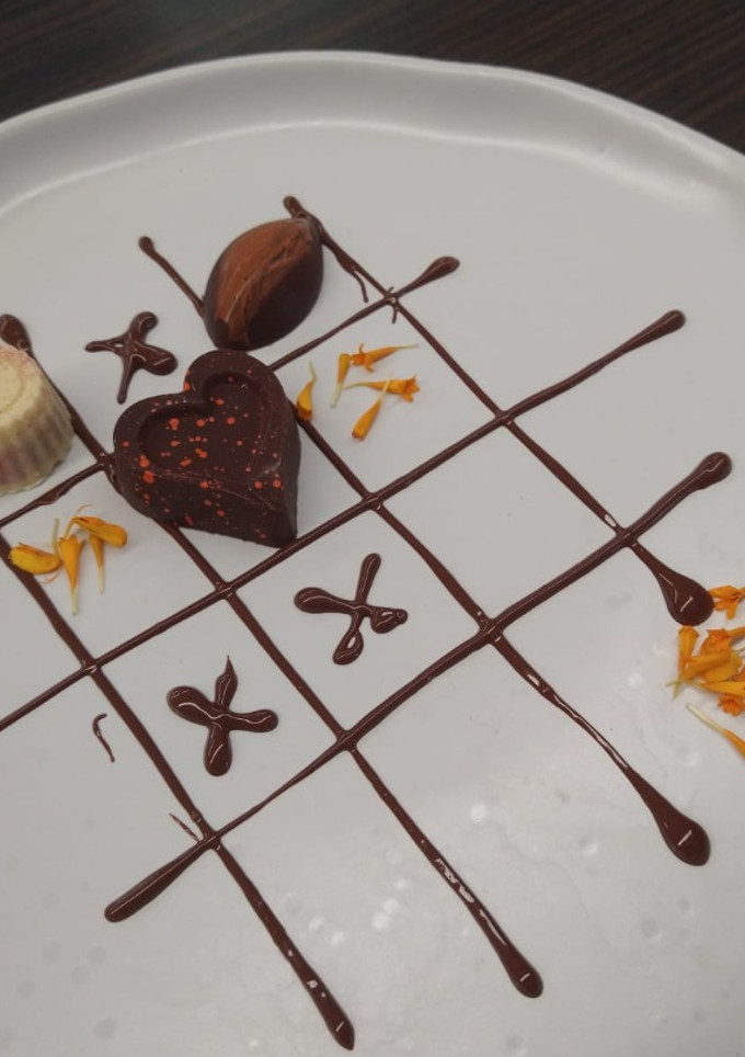 Una foto de Bombones de chocolate oscuro con relleno de maracuyá y mezcal