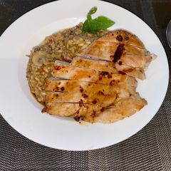 A picture of Spicy risotto with mushrooms and glazed chicken breast.