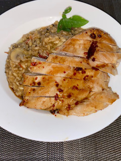 A picture of Spicy risotto with mushrooms and glazed chicken breast.