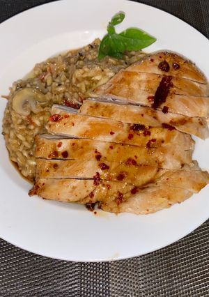 A picture of Spicy risotto with mushrooms and glazed chicken breast.