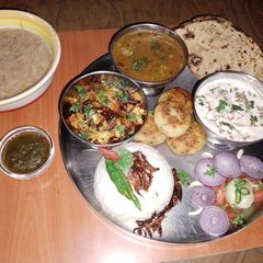 A picture of Vegetarian Punjabi thali 🌶️🍅🍋🥔🧅🥒🫑.