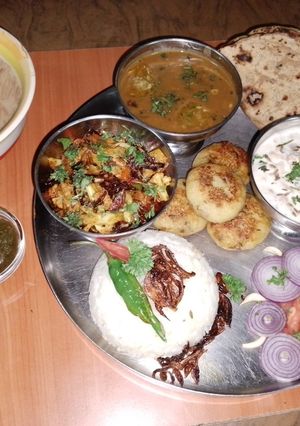 A picture of Vegetarian Punjabi thali 🌶️🍅🍋🥔🧅🥒🫑.