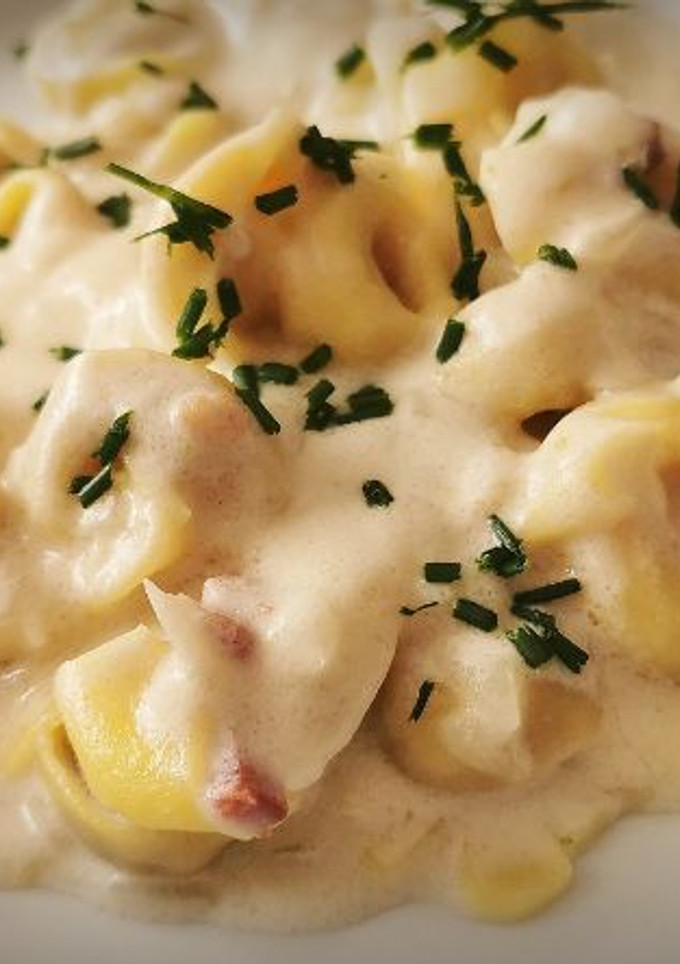 Una foto de Tortellini de carne a la crema con jamón y Parmesano