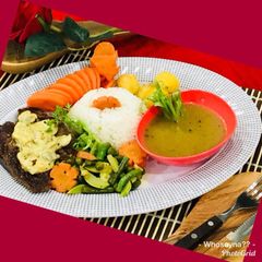 A picture of Whosayna’s Pepper Steak topped with Sauce and Stir fried Veggies.