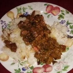 A picture of Beef tips with mushrooms over rice.