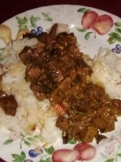 A picture of Beef tips with mushrooms over rice.