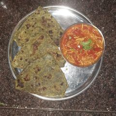 Spinach mint paratha with sev tomato sabji A picture of Spinach mint paratha with sev tomato sabji.