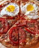 Pizza con huevo frito y rodajas de tomate