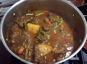 Una foto de Côte de boeuf avec légumes et vin
