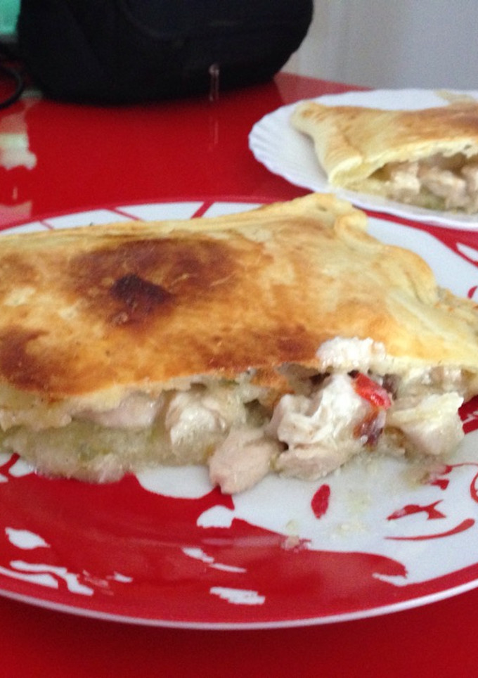 Una foto de Empanada de pollo en salsa y queso de cabra