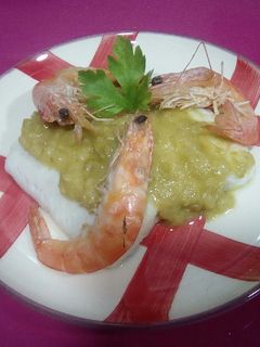 Una foto de Merluza en salsa de puerros y cebolla con langostinos