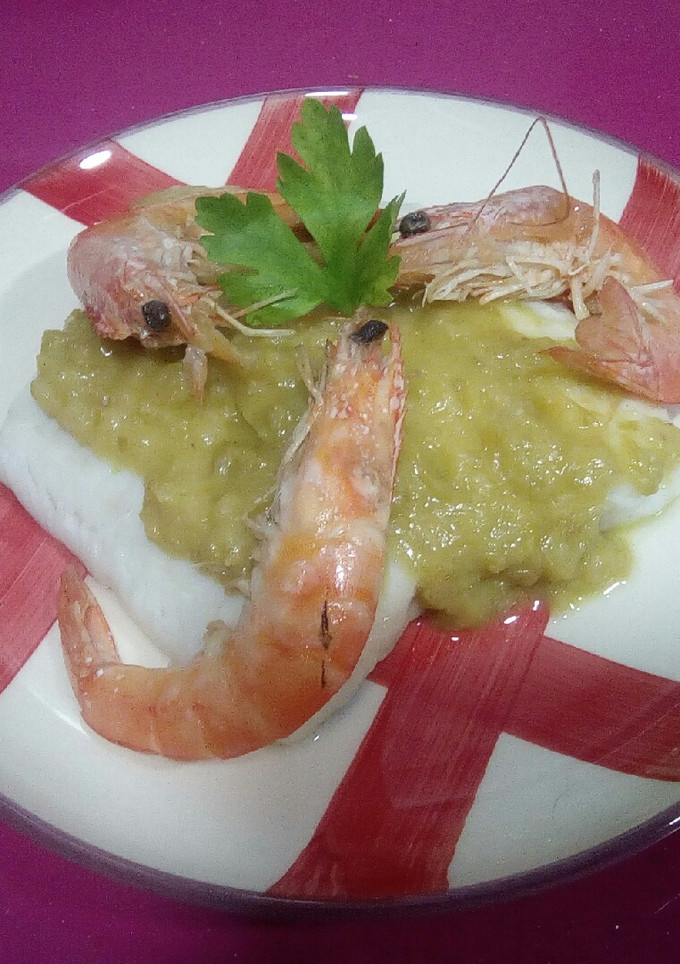 Una foto de Merluza en salsa de puerros y cebolla con langostinos