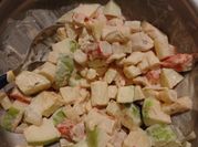 Una foto de ensalada con manzana y surimi