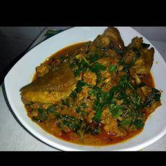 A picture of Banga soup with goat meat and scent leaves.