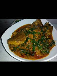 A picture of Banga soup with goat meat and scent leaves.
